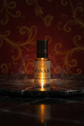 A small amber liquid bottle with a shiny gold cap and a white label reading 'IONARO AMBER MIX' stands on a glass display counter inside a retail shop. Shelves with assorted items are blurred in the background.