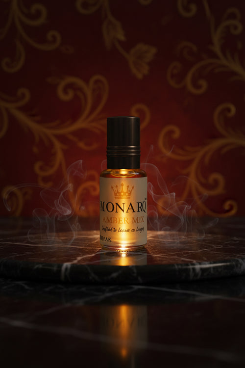 A small amber liquid bottle with a shiny gold cap and a white label reading 'IONARO AMBER MIX' stands on a glass display counter inside a retail shop. Shelves with assorted items are blurred in the background.